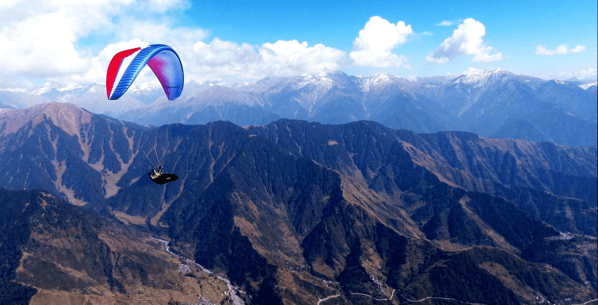 Paragliding above the mountain valleys near Auli
